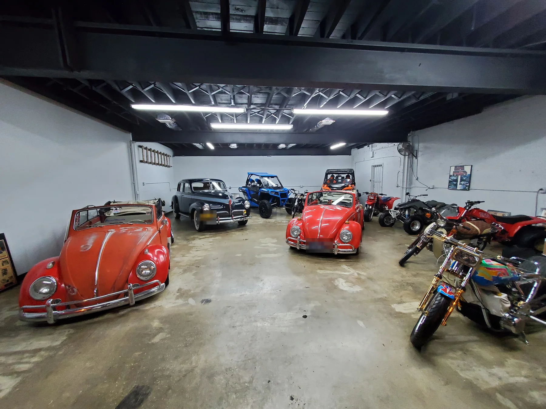 Classic cars, motorcycles, and off-road vehicles arranged inside the shop