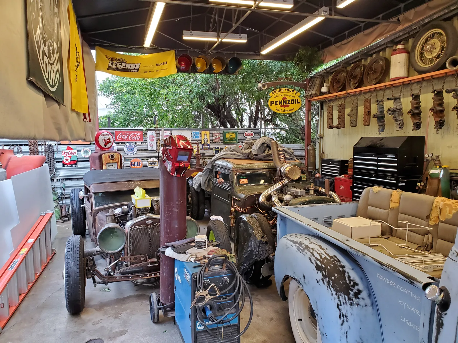 Red's Miami workshop with fabrication equipment and automotive projects