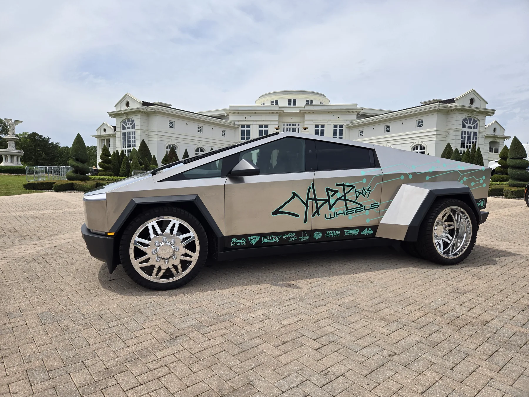 Cyber Dos Wheels Cyber Dually in side profile with polished wheels outside an estate