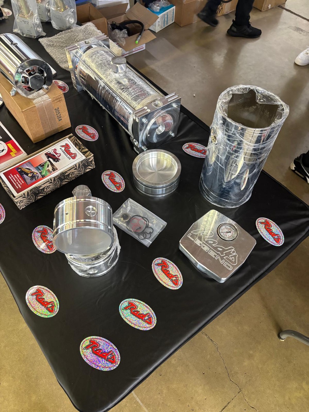 Red's Miami stickers and polished hydraulic products displayed at a SEMA booth
